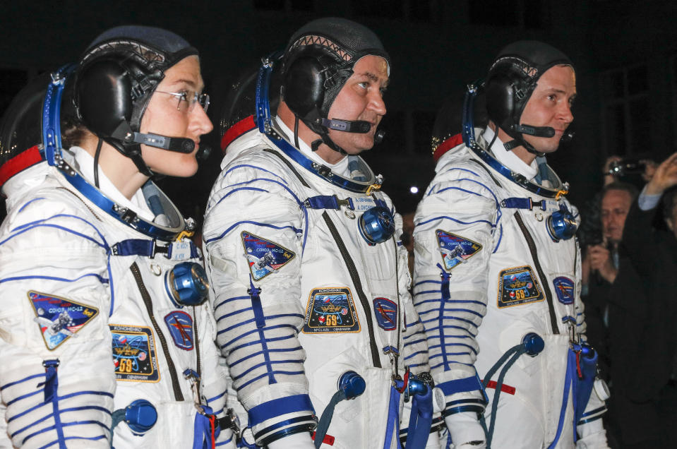 U.S. astronauts Christina Hammock Koch, left, Nick Hague, right, and Russian cosmonaut Alexey Ovchinin, members of the main crew of the expedition to the International Space Station (ISS), walk prior the launch of Soyuz MS-12 space ship at the Russian leased Baikonur cosmodrome, Kazakhstan, Thursday, March 14, 2019. (AP Photo/Dmitri Lovetsky, Pool)