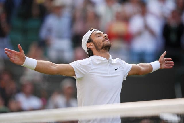 Lorenzo Musetti holds his arms out wide in celebration