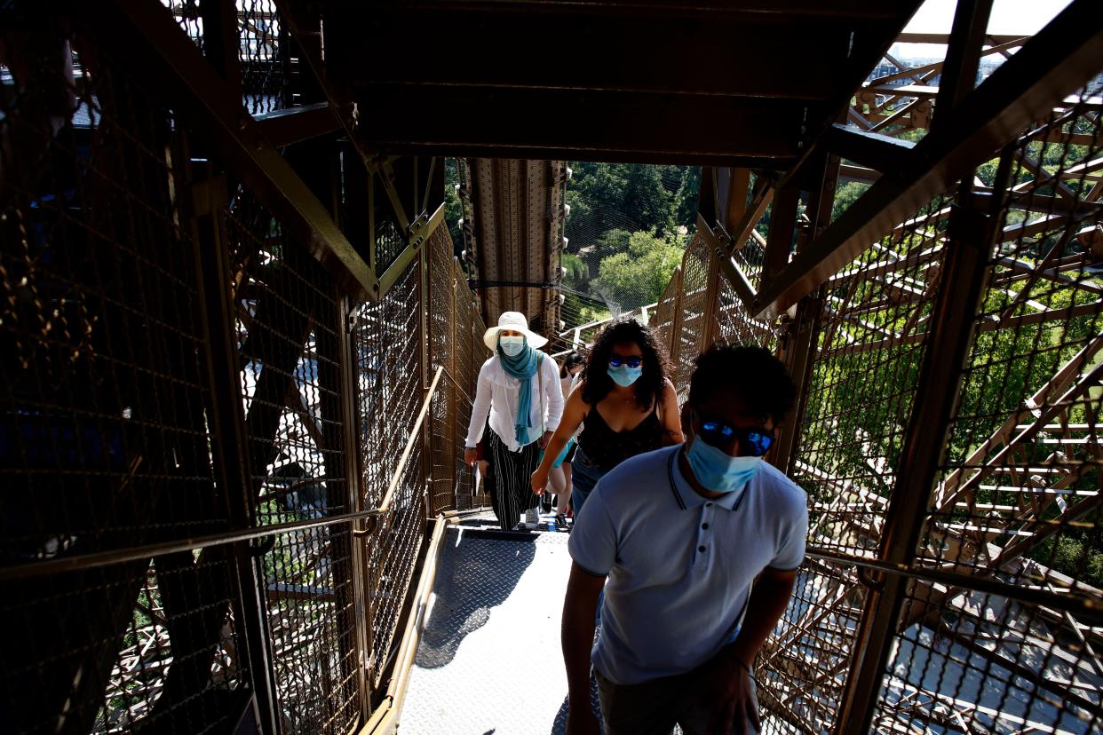 People climb stairs as they visit the Eiffel Tower in Paris on June 25, 2020.