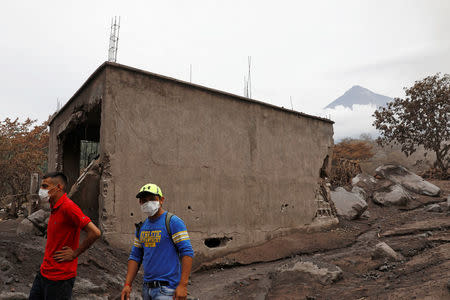 People inspect an affected area after the eruption of the Fuego volcano in Escuintla, Guatemala, June 8, 2018. REUTERS/Carlos Jasso