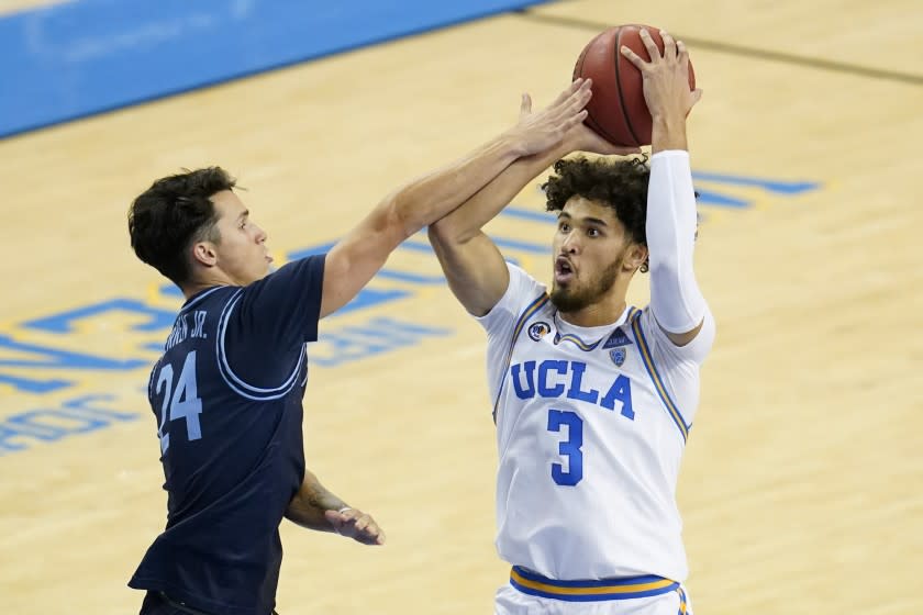 UCLA guard Johnny Juzang, right, is fouled by San Diego guard Chris Herren Jr. during the second half of an NCAA college basketball game Wednesday, Dec. 9, 2020, in Los Angeles. (AP Photo/Ashley Landis)