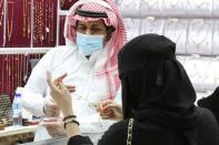 A Saudi woman buys jewellery at a shop in the gold market before the expected increase of VAT to 15%, in Riyadh