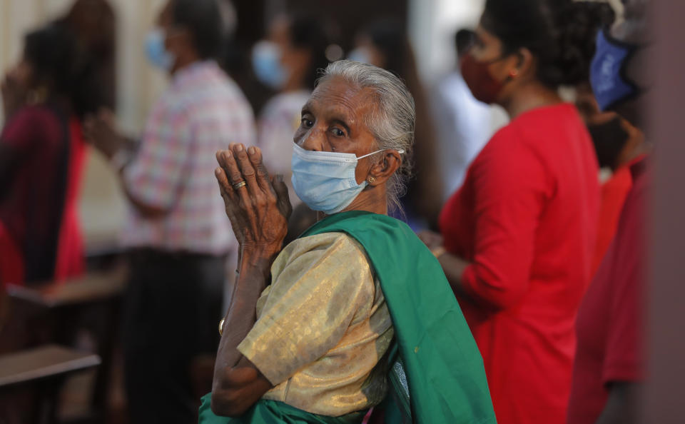 An elderly Sri Lankan Christian wearing a mask as a precaution against the coronavirus prays inside a church on Christmas in Colombo, Sri Lanka, Friday, Dec. 25, 2020. (AP Photo/Eranga Jayawardena)