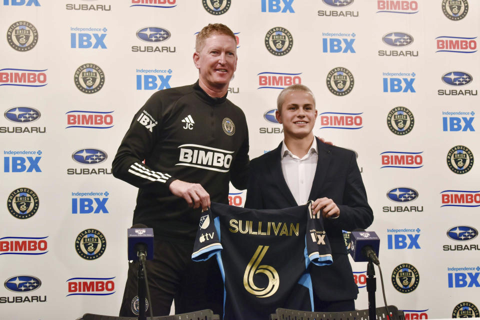 Philadelphia Union manager Jim Curtin, left, and new player Cavan Sullivan, 14, hold up Sullivan's No. 6 jersey during an MLS soccer news conference at Subaru Park in Chester, Pa., Thursday, May 9, 2024. (Jonathan Tannenwald/The Philadelphia Inquirer via AP