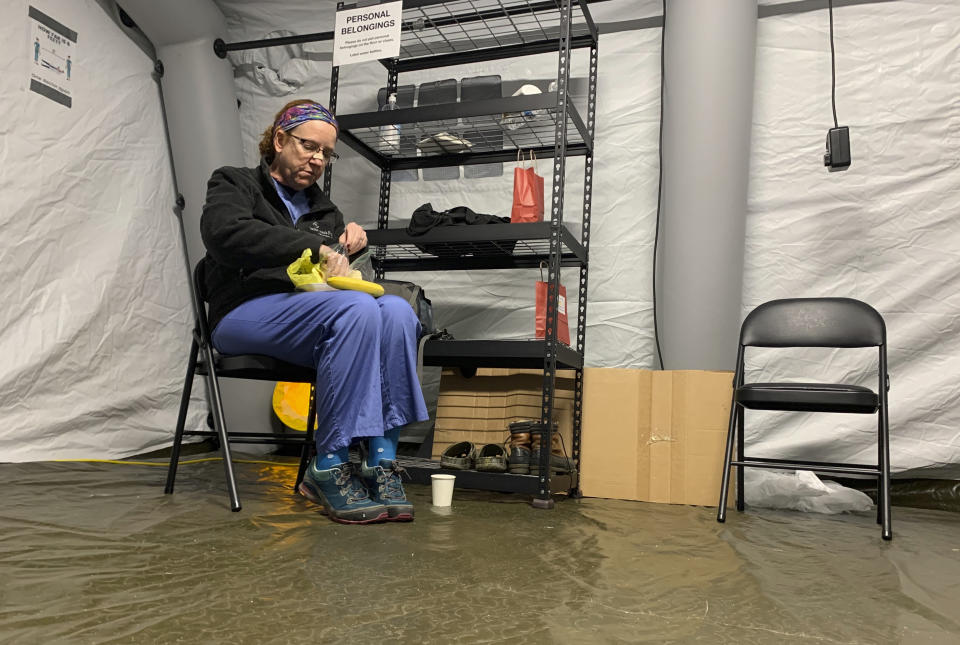 Chris Rutledge, a nurse for Samaritan’s Purse, eats lunch, Friday, Jan. 15, 2021, during the only short break of her 12-hour shift inside the COVID-19 field hospital built by the Christian relief organization, in Lenoir, N.C. Caldwell Memorial Hospital asked for help from Samaritan’s Purse as cases in the North Carolina foothills skyrocketed and bed space dwindled. (AP Photo/Sarah Blake Morgan)