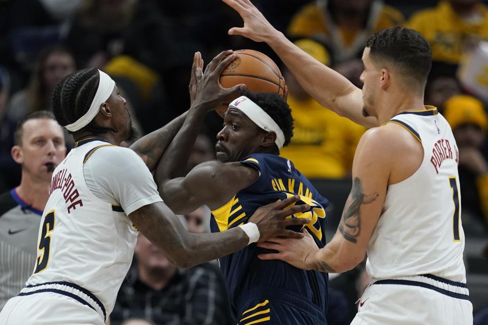 Indiana Pacers forward Pascal Siakam (43) is defended by Denver Nuggets guard Kentavious Caldwell-Pope (5) and forward Michael Porter Jr. (1) during the first half of an NBA basketball game, Tuesday, Jan. 23, 2024, in Indianapolis. (AP Photo/Darron Cummings)
