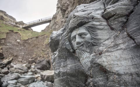 The carving at the opening of Merlin’s Cave; - Credit: Getty Images