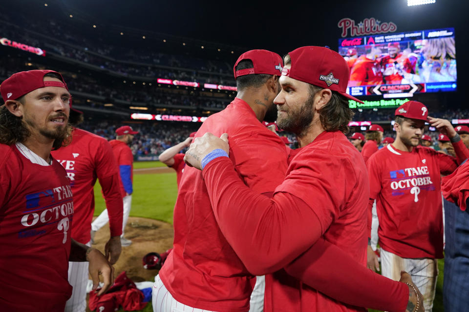 Philadelphia Phillies' Bryce Harper, right, and Seranthony Dominguez celebrate after winning a baseball game against the Pittsburgh Pirates to clinch a wild-card playoff spot, Tuesday, Sept. 26, 2023, in Philadelphia. (AP Photo/Matt Slocum)