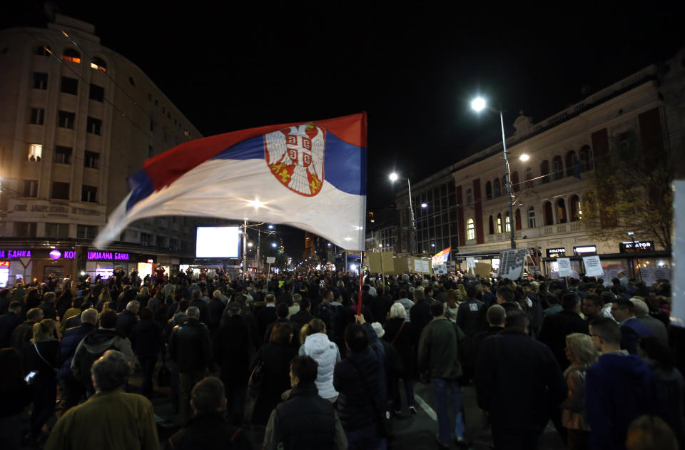 A man holds a Serbian flag during a protest march in Belgrade, Serbia, Saturday, March 9, 2019. The demonstrations in Serbia have lasted for three months seeking more democracy in the Balkan country that is firmly under control of the populist leader Aleksandar Vucic. (AP Photo/Darko Vojinovic)