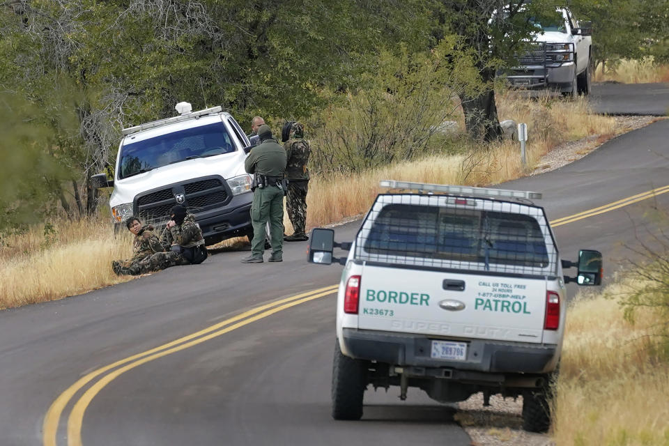 A pair of Customs and Border Patrol agents detain three migrants leading up to Montezuma's Pass in Coronado National Memorial, Thursday, Dec. 10, 2020, in Hereford, Ariz. Construction of the border wall, mostly in government owned wildlife refuges and Indigenous territory, has led to environmental damage and the scarring of unique desert and mountain landscapes that conservationists fear could be irreversible. (AP Photo/Matt York)
