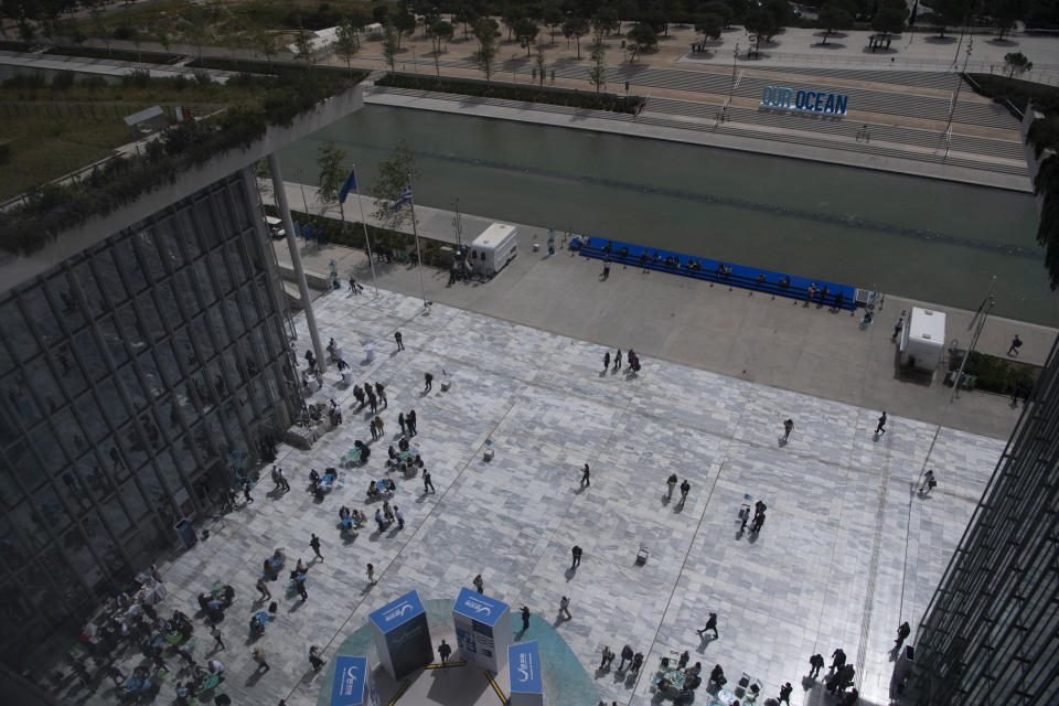 People walk on the Stavros Niarchos Foundation Cultural Center's square during the 'Our Ocean Conference' in Athens, Greece, Tuesday, April 16, 2024. Greece aims to create two large marine parks as part of a 780 million euro ($830 million) program to protect biodiversity and marine ecosystems, with the plans to be formally announced at an international oceans conference starting in Athens Tuesday. (AP Photo/Michael Varaklas)