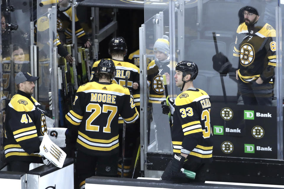 Fans watch Boston Bruins defensemen Zdeno Chara (33), John Moore (27) and teammates leave the ice after they were defeated by the Columbus Blue Jackets in overtime at an NHL hockey game, Thursday, Jan. 2, 2020, in Boston. (AP Photo/Elise Amendola)