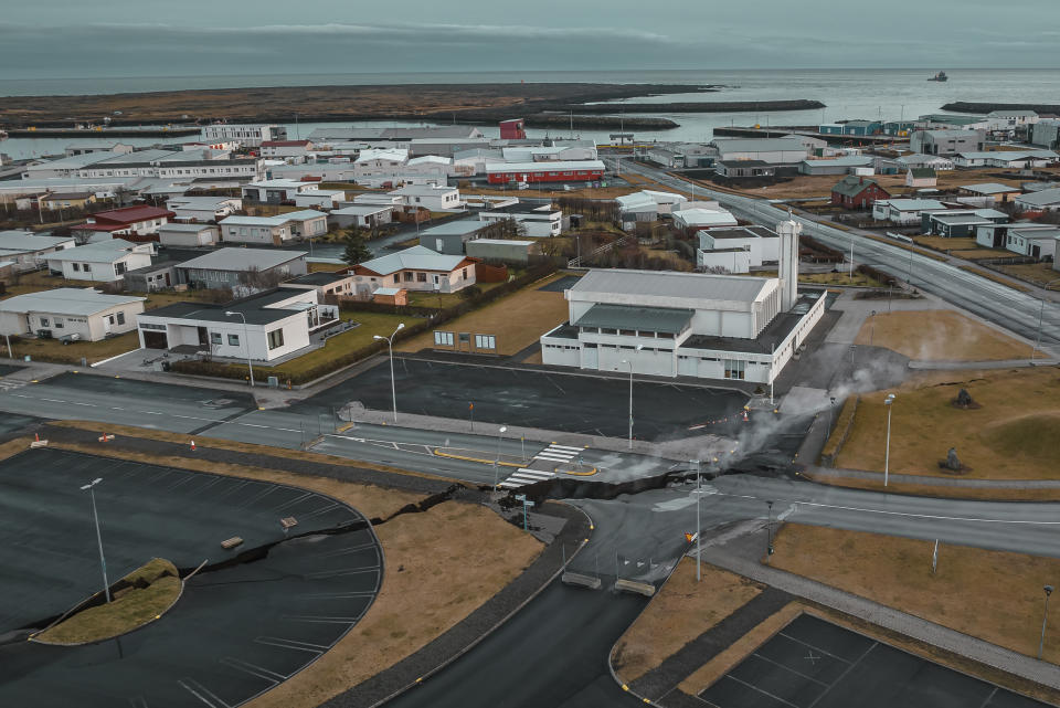 This image taken with a drone shows the town of Grindavik, Iceland, as a Coast Guard vessel patrol, Thursday, Nov. 16, 2023. Residents of a fishing town in southwestern Iceland have left their homes after increasing concern about a potential volcanic eruption caused civil defense authorities to declare a state of emergency in the region. Iceland's Meteorological Office says police decided to evacuate Grindavik after recent seismic activity in the area moved south toward the town. (AP Photo/Bjorn Steinbekk)