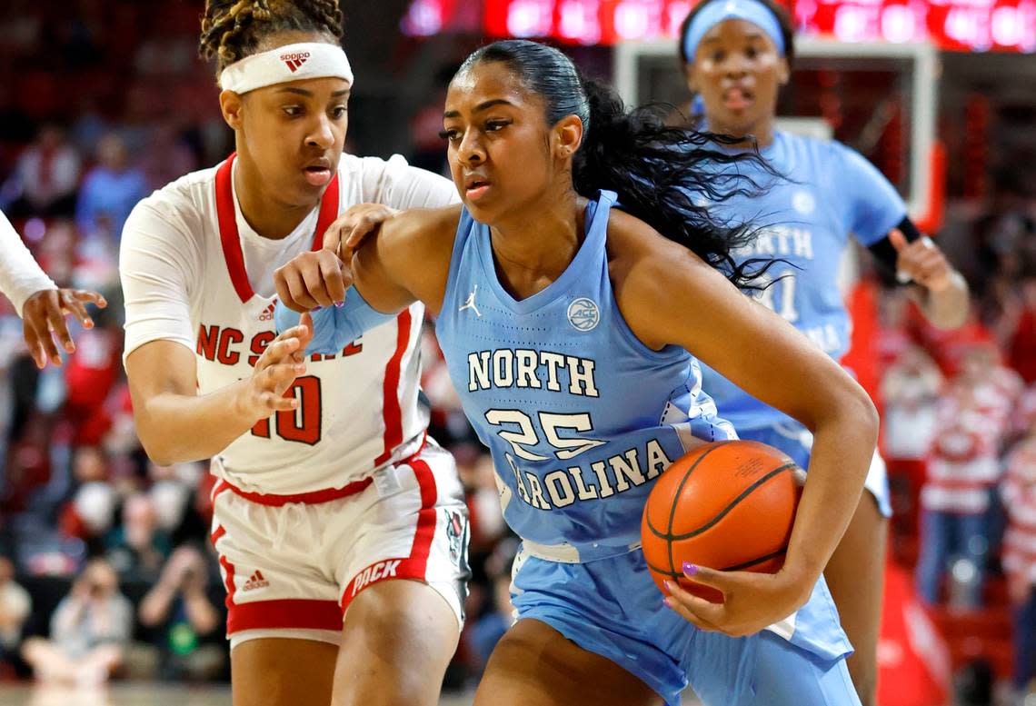 North Carolina’s Deja Kelly (25) drives by N.C. State’s Aziaha James (10) during the first half of N.C. State’s game against UNC at Reynolds Coliseum in Raleigh, N.C., Thursday, Feb. 16, 2023.