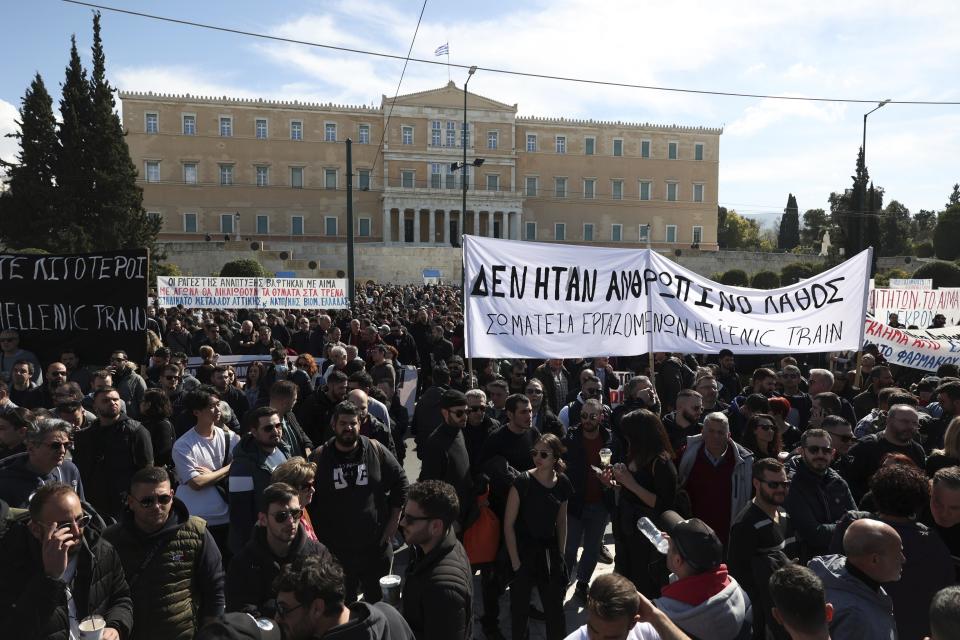 People gather during a protest outside the Greek parliament, in Athens, Greece, Sunday, March 5, 2023. Thousands protesters, take part in rallies around the country for fifth day, protesting the conditions that led the deaths of dozens of people late Tuesday, in Greece's worst recorded rail accident. The banner reads "It wasn't human error." (AP Photo/Yorgos Karahalis)