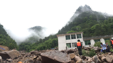 Paramilitary policemen search for missing people at the site of a landslide in Sanming, Fujian province, China, May 8, 2016. REUTERS/Stringer