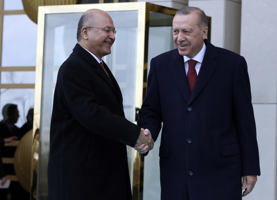 Turkey's President Recep Tayyip Erdogan, right, and Iraq's President Barham Salih shake hands during a welcome ceremony in Ankara, Turkey, Thursday, Jan. 3, 2019. The two were expected to discus bilateral and regional issues, including Syria.(AP Photo/Burhan Ozbilici)