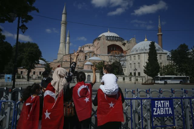 People, draped in Turkish flags stand outside the now closed Byzantine-era Hagia Sophia (Emrah Gurel/AP)