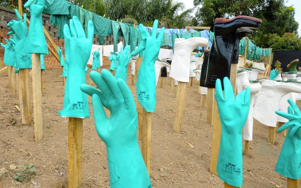 Gloves and boots used by medical staff, drying in the sun, at a centre for victims of the Ebola virus in Guekedou, in 2014 - AFP