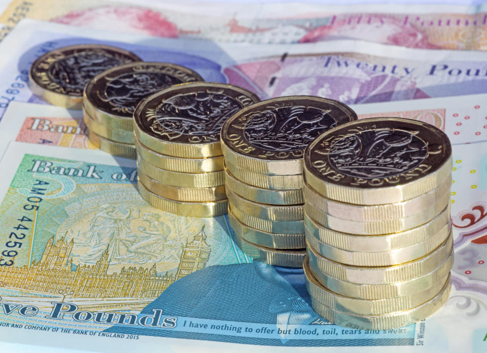 savings Five stacks of newly minted one pound coins arranged in increasing height on British pound notes.