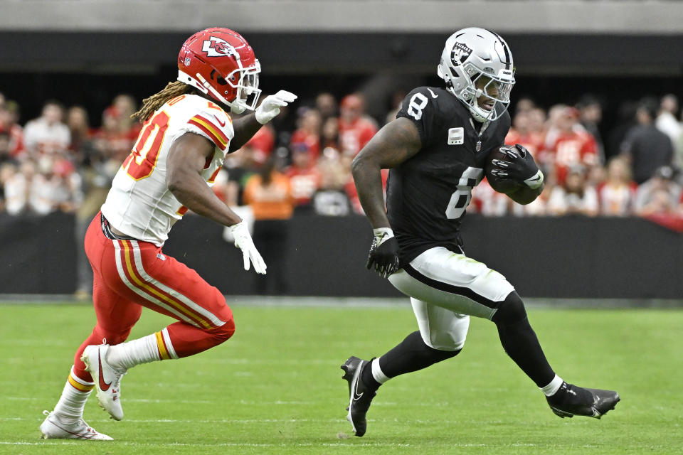 Las Vegas Raiders running back Josh Jacobs (8) runs against Kansas City Chiefs safety Justin Reid during the first half of an NFL football game, Sunday, Nov. 26, 2023, in Las Vegas. (AP Photo/David Becker)