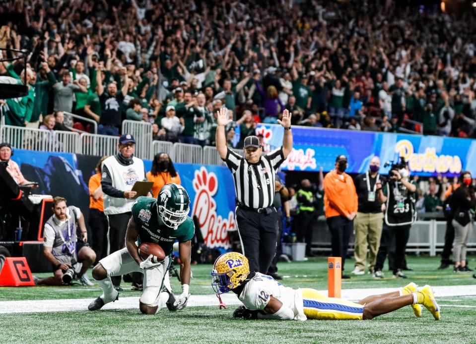 Michigan State wide receiver Jayden Reed catches for a touchdown against Pittsburgh defensive back M.J. Devonshire during the second half of the 31-21 win over Pittsburgh in the Peach Bowl at the Mercedes-Benz Stadium in Atlanta on Thursday, Dec. 30, 2021.