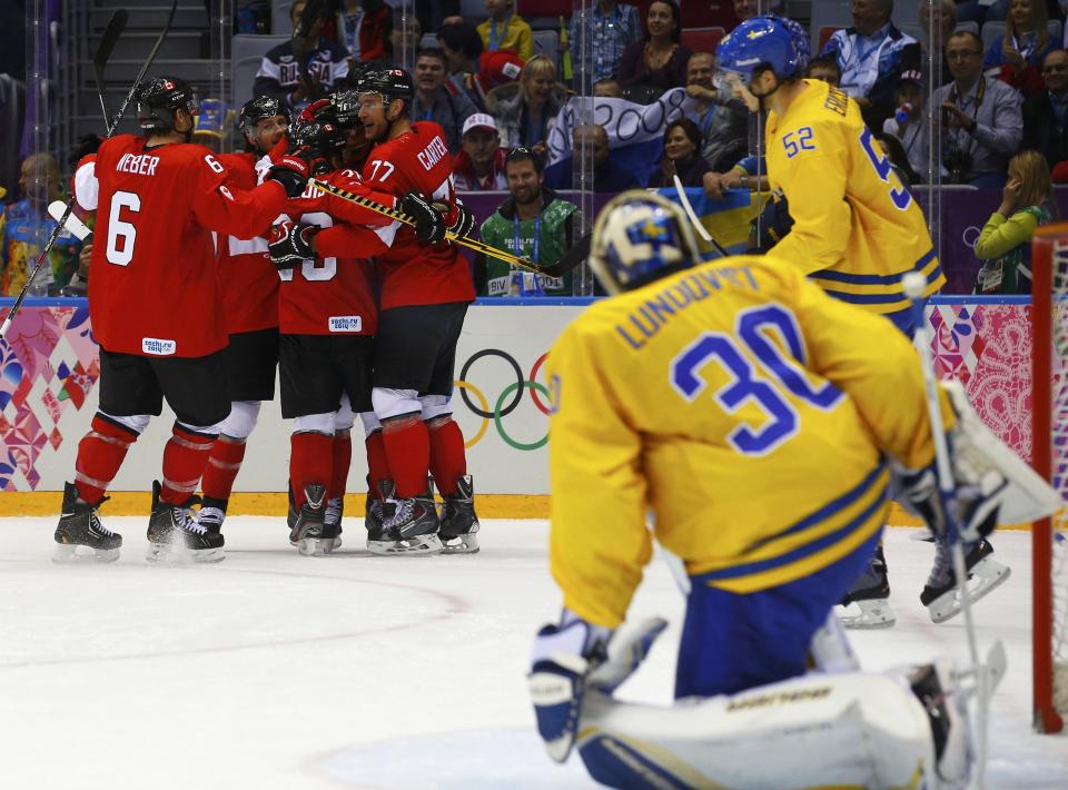 Canada's Jonathan Toews celebrates his goal with his linemates after scoring on Sweden's goalie Henrik Lundqvist (30) as Sweden's Jonathan Ericsson skates past during the first period of their men's ice hockey gold medal game at the Sochi 2014 Winter Olympic Games February 23, 2014. REUTERS/Brian Snyder (RUSSIA - Tags: OLYMPICS SPORT ICE HOCKEY)