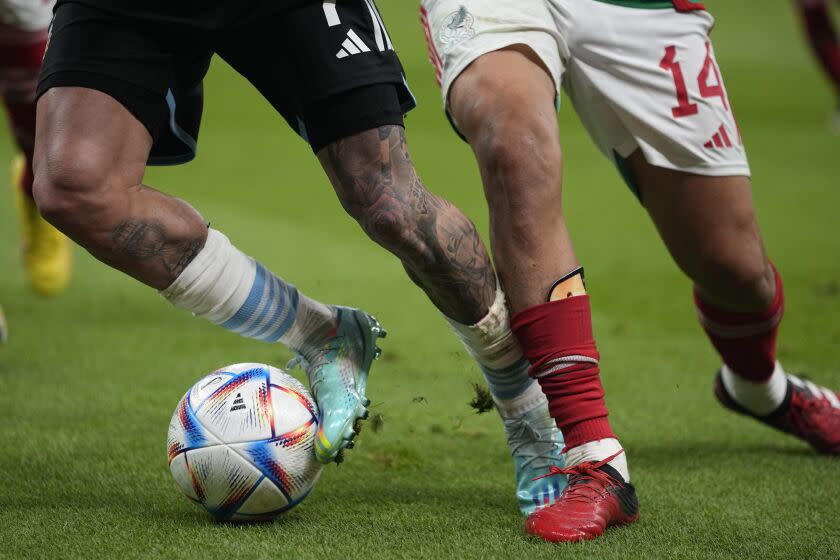 Argentina's Rodrigo De Paul, left, is challenged by Mexico's Erick Gutierrez during the World Cup group C soccer match between Argentina and Mexico, at the Lusail Stadium in Lusail, Qatar, Saturday, Nov. 26, 2022. (AP Photo/Ariel Schalit)