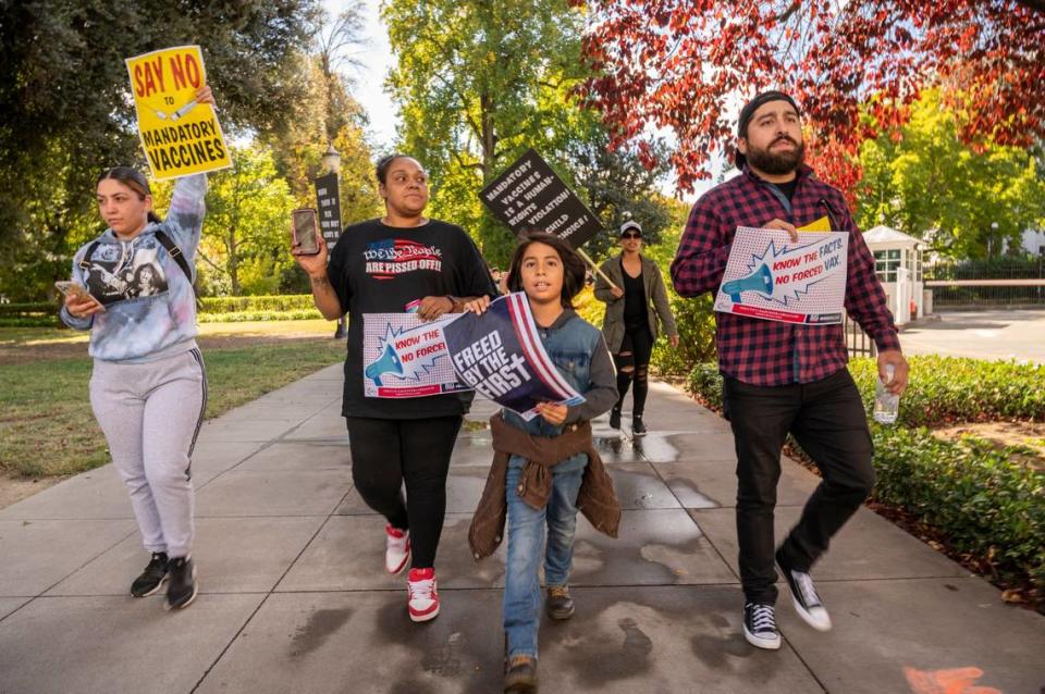 Nine-year-old Irah Arellano, center, of Gridley leads a group of marchers at the state Capitol, accompanied by his father Miguel, right, on Monday. Thousands participated in a Keep Your Kids Home From School rally organized on social media by two Placer County mothers.