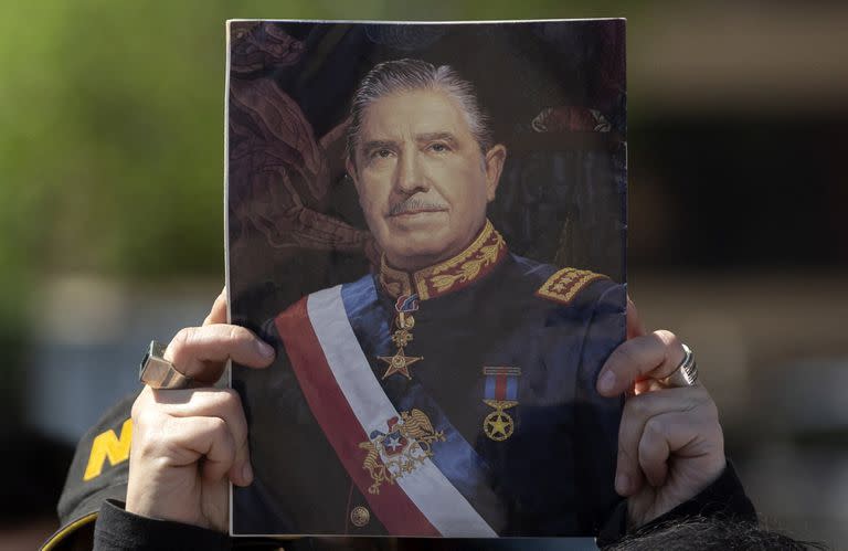 Un simpatizante de Augusto Pinochet muestra un retrato del dictador, en Santiago de Chile. (CLAUDIO REYES / AFP)