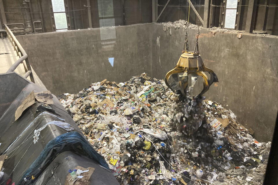 Garbage is dropped into a trash bunker at ecomaine, Tuesday, June 22, 2021, in Portland, Maine. Waste-to-energy converters like ecomaine are seeing an uptick in the amount of trash they collect to produce power as the coronavirus pandemic winds down in the U.S. These facilities burn garbage to create electricity. Environmentalists and renewable energy advocates are debating whether creating more energy by burning the excess waste is a safe idea. (AP Photo/Patrick Whittle)