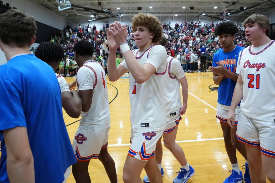 Olentangy Orange's Devin Brown (5) and teammates leave the court after their 50-42 win over Newark in a regional semifinal Wednesday at Ohio Dominican.