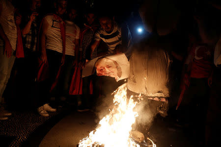 A supporter of Turkish President Tayyip Erdogan prepares to burn a photo of U.S.-based cleric Fethullah Gulen during a pro-government demonstration on Taksim Square in Istanbul, Turkey, July 18, 2016. REUTERS/Alkis Konstantinidis