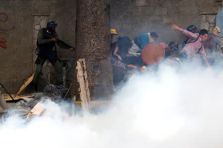 Demonstrators run away from a riot security force member at a rally against Venezuelan President Nicolas Maduro's government in Caracas, Venezuela July 26, 2017. REUTERS/Carlos Garcia Rawlins