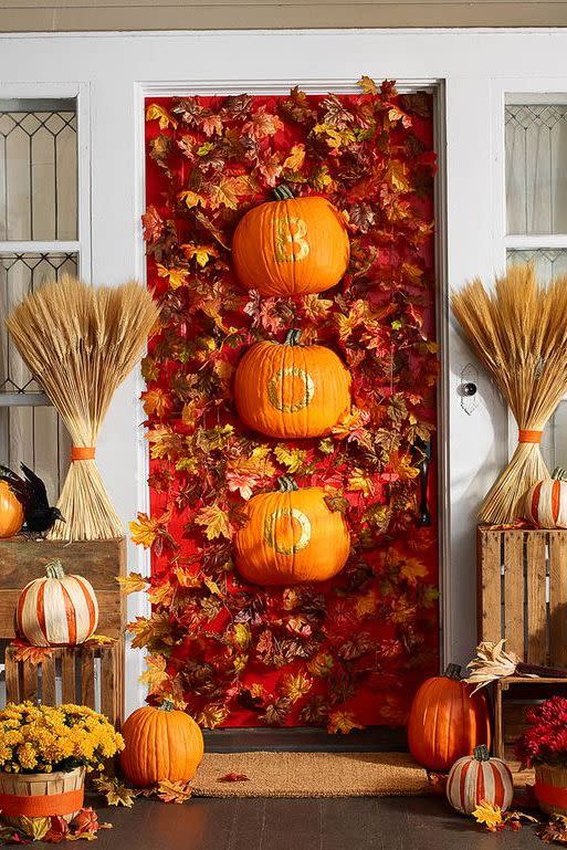 <p>Fun-Kins, which are artificial, carvable pumpkins, dress up this leaf-covered door with other fall accents. </p><p><strong>Make the Boo Door:</strong> Use a utility knife to halve two Fun-Kins lengthwise. Print and cut out stencils for the word BOO. Trace each letter onto a halved Fun-Kin with a pencil. Use small paintbrush to apply gold enamel paint inside lines; let dry. Hang on door with Command wire hooks. </p>