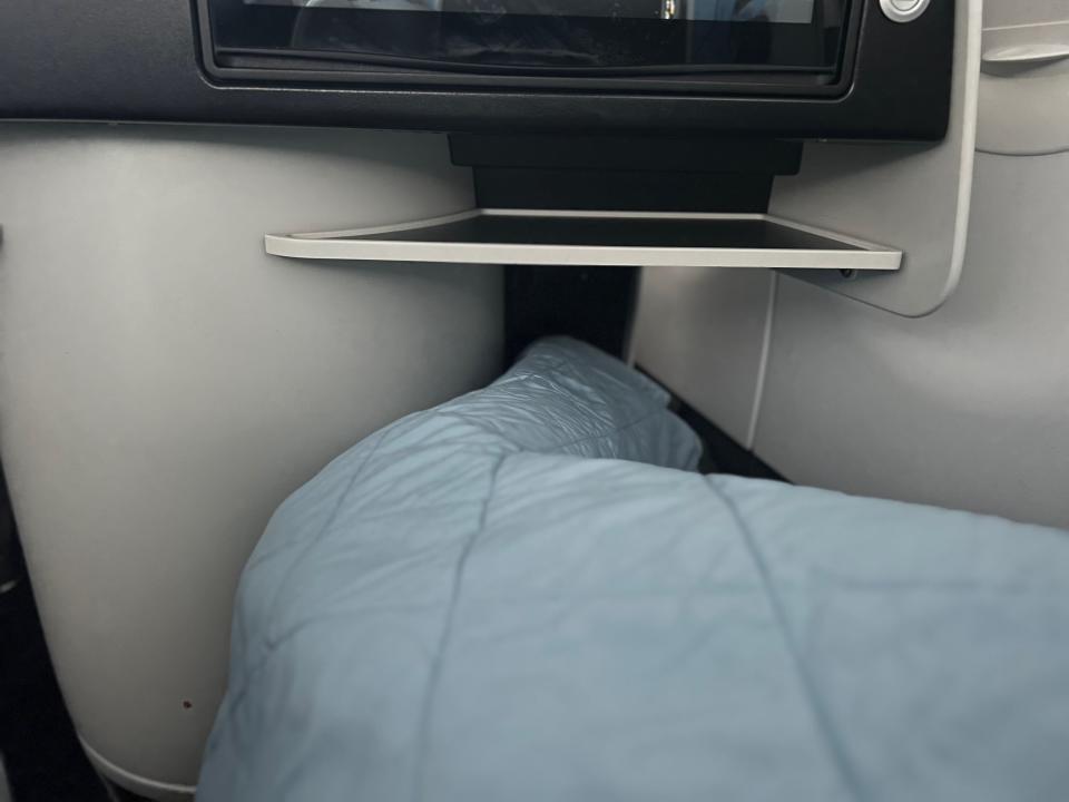 Flying on La Compagnie all-business class airline from Paris to New York — me with my legs almost at the end of the foot nook.