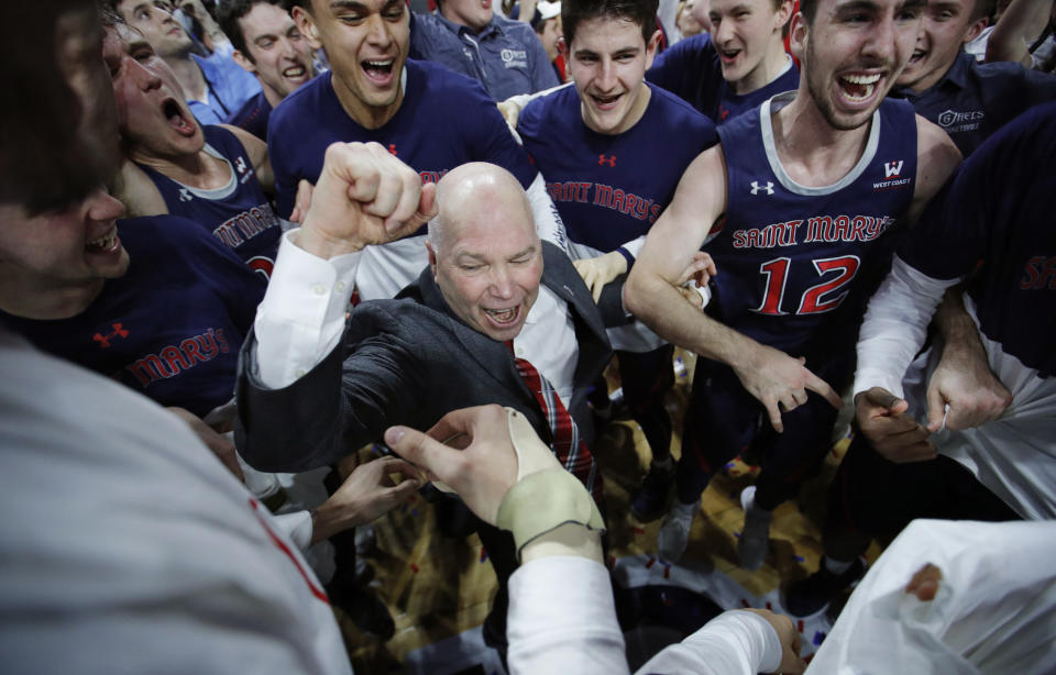 FILE - In this March 12, 2019, file photo, St. Mary's head coach Randy Bennett celebrates with his team after they defeated Gonzaga 60-47 in an NCAA college basketball game in the championship of the West Coast Conference tournament in Las Vegas. In all of his successful years at tiny Saint Mary's College and the challenge of turning around a program almost two decades ago, this NCAA Tournament berth is perhaps the most gratifying yet for Bennett. (AP Photo/John Locher, File)