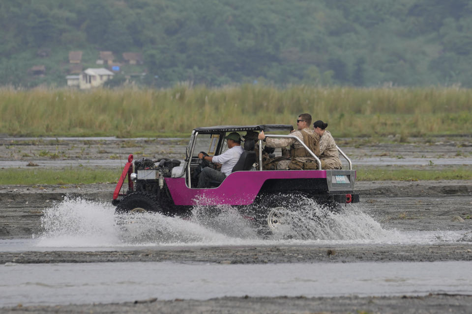 American Marines ride a custom jeepney across a stream during annual combat drills between the Philippine Marine Corps and U.S. Marine Corps in Capas, Tarlac province, northern Philippines, Thursday, Oct. 13, 2022. Truck-mounted launchers blasted off rockets Thursday and U.S. stealth fighter jets streaked across the northern Philippine sky in a combat drill and latest display of American firepower in a region where Washington has tried to deter what it warns as China's growing aggression. (AP Photo/Aaron Favila)