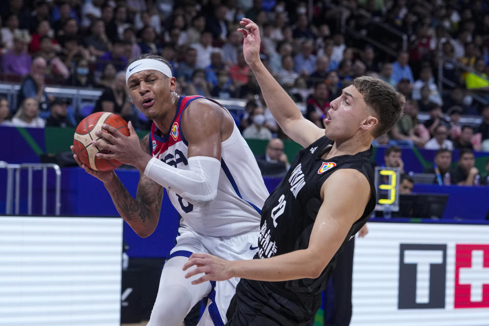 U.S. forward Paolo Banchero (8) is fouled by New Zealand forward Hyrum Harris (22) during the second half of a Basketball World Cup group C match in Manila, Saturday, Aug. 26, 2023. (AP Photo/Michael Conroy)