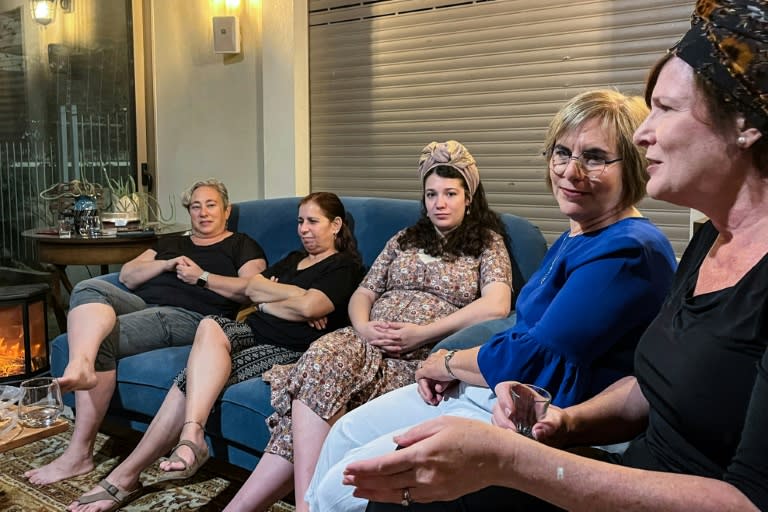 Sharon (à droite), une Israélienne de 53 ans dont le fils soldat a été déployé à Gaza, est assise avec des amis dans sa maison dans le nord d'Israël, le 13 juin 2024 (Antone BOYER)