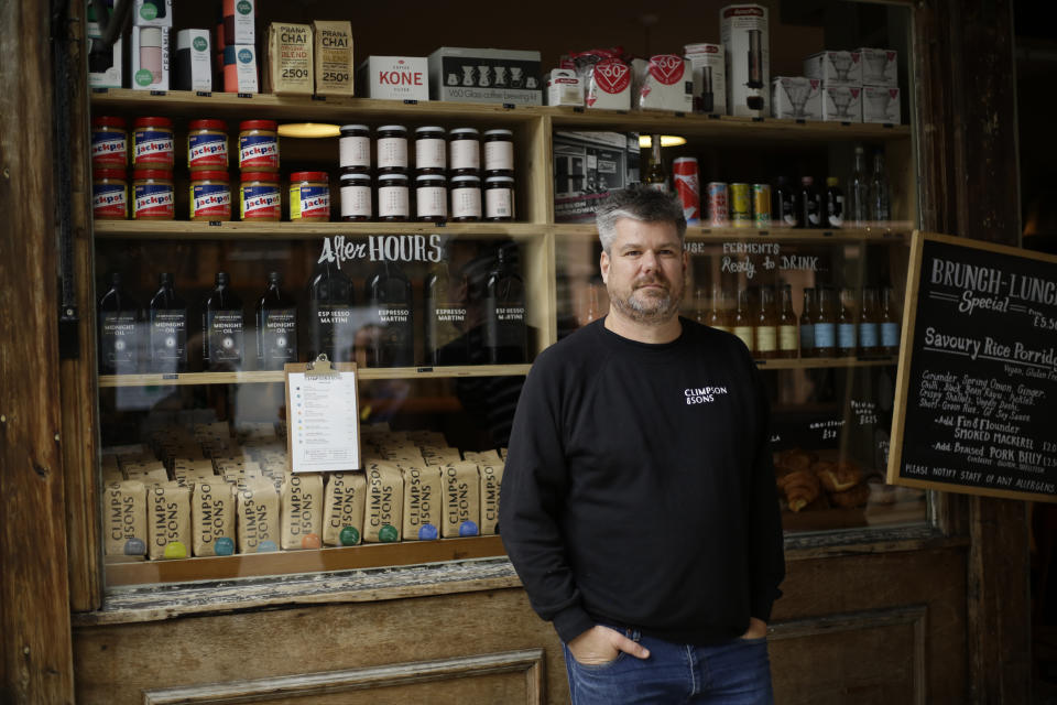 Danny Davies the Commercial Director of Climpson & Sons, poses for a portrait outside their specialty coffee cafe, which is allowed to stay open for takeaway orders during England's second coronavirus lockdown, on Broadway Market in Hackney, east London, Tuesday, Nov. 17, 2020. Small businesses all over the world are struggling to cope as the coronavirus forces changes in consumer habits, but the U.K. also faces uncertainty of the Brexit split from Europe. (AP Photo/Matt Dunham)