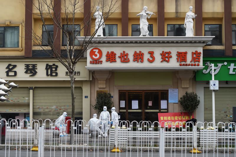 Workers in protective suits are seen outside a medical observation site for those under quarantine in Wuhan, the epicentre of the novel coronavirus outbreak