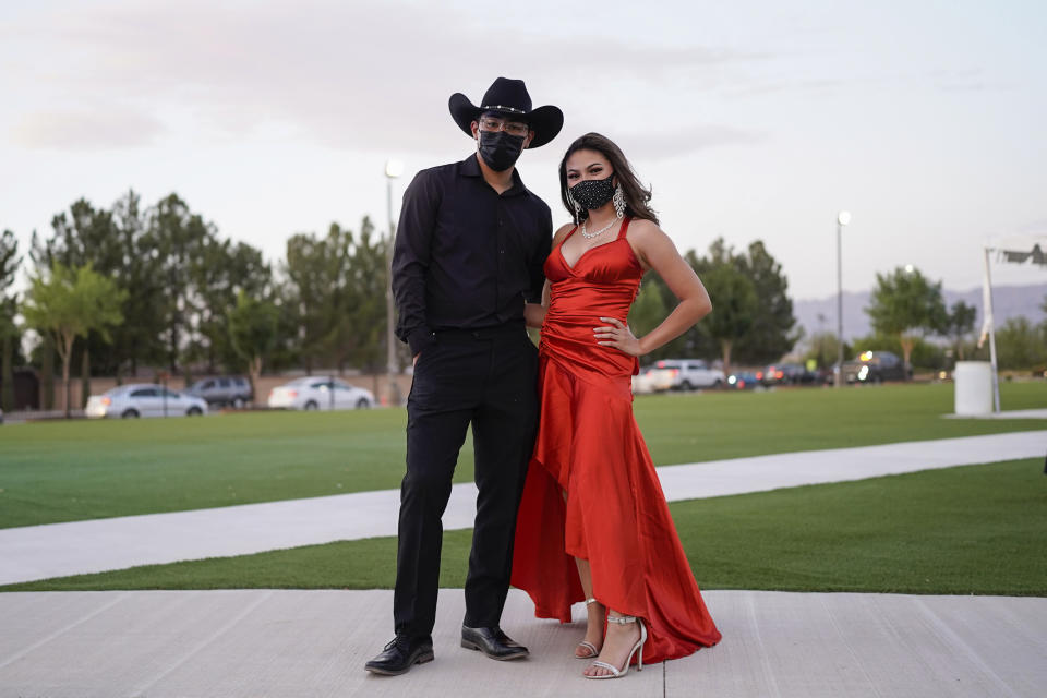 Sean de la Luz, 18, and Nalanie Miranda, 18, wear face masks for their prom at the Grace Gardens Event Center in El Paso, Texas on Friday, May 7, 2021. Around 2,000 attended the outdoor event at the private venue after local school districts announced they would not host proms this year. Tickets cost $45. (AP Photo/Paul Ratje)