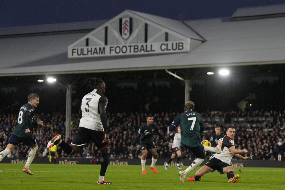 Fulham's Joao Palhinha, right, stops a shot from Arsenal's Bukayo Saka (7) during the English Premier League soccer match between Arsenal and Fulham at Craven Cottage stadium in London, Sunday, Dec. 31, 2023. (AP Photo/Alastair Grant)