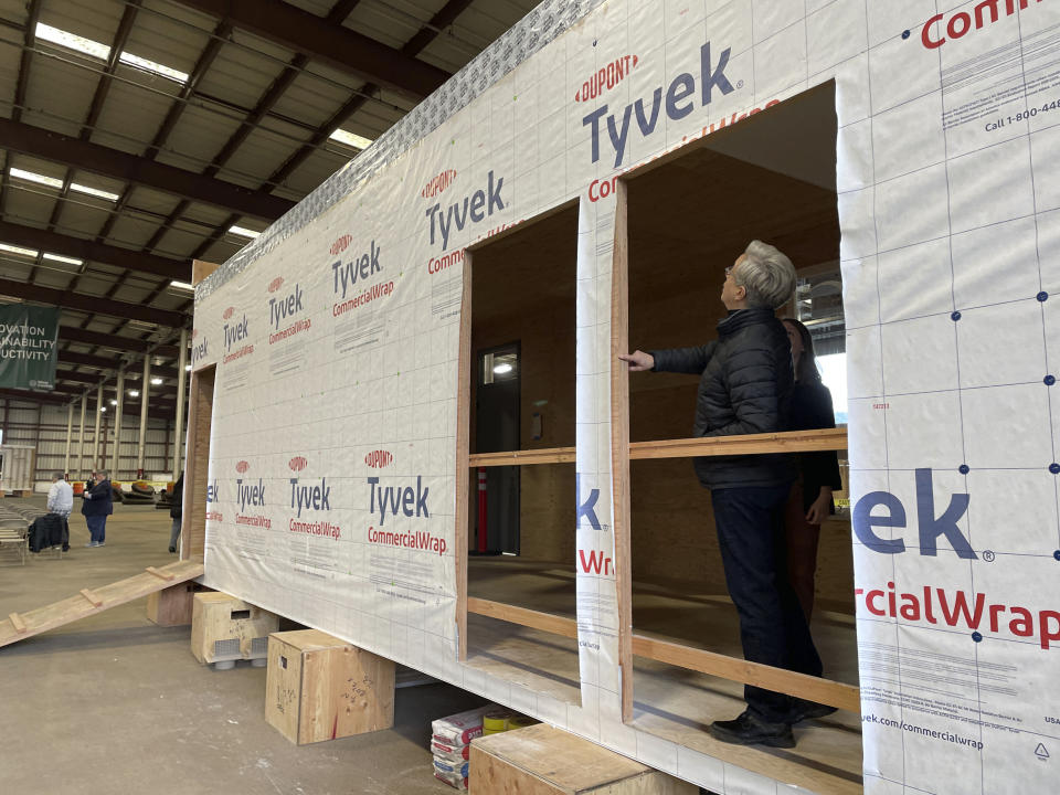 FILE - Oregon Gov. Tina Kotek examines a mass timber affordable housing prototype at the Port of Portland in Portland, Ore., on Jan. 27, 2023. Oregon lawmakers are expected to approve $200 million in spending to tackle the state's homelessness and housing crises. The package will be voted on by the state Senate on Tuesday, March 21, 2023, after passing the House with bipartisan support.(AP Photo/Claire Rush, File)