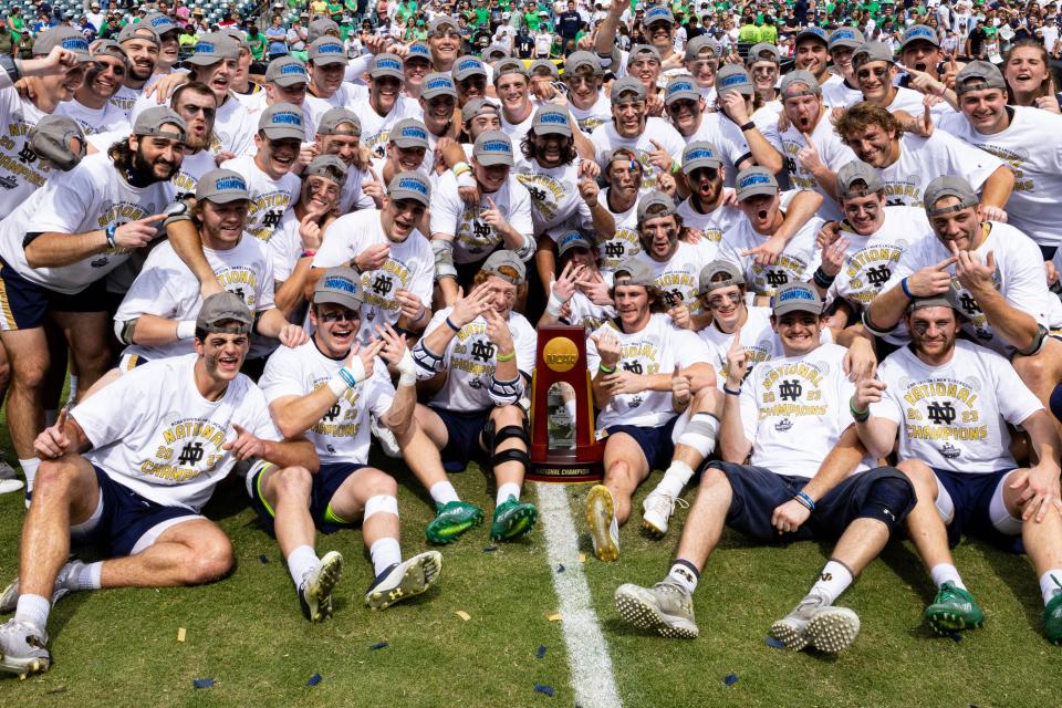The Notre Dame Fighting Irish pose with the national championship trophy after beating Duke in the NCAA men's lacrosse final.