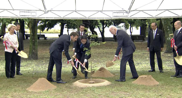 In this image from a video, French President Emmanuel Macron, third left, Japanese Prime Minister Fumio Kishida, center, and U.S. President Joe Biden, third right, plant a tree during a visit at the Peace Memorial Park as part of the G7 Summit in Hiroshima, western Japan Friday, May 19, 2023. (Kyodo News via AP)