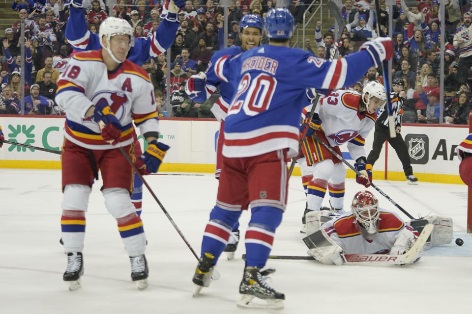 New Jersey Devils goaltender Vitek Vanecek (41) watches as New York Rangers left wing Chris Kreider (20) celebrates after scoring during the second period of an NHL hockey game, Saturday, Jan. 7, 2023, in Newark, N.J. (AP Photo/Mary Altaffer)