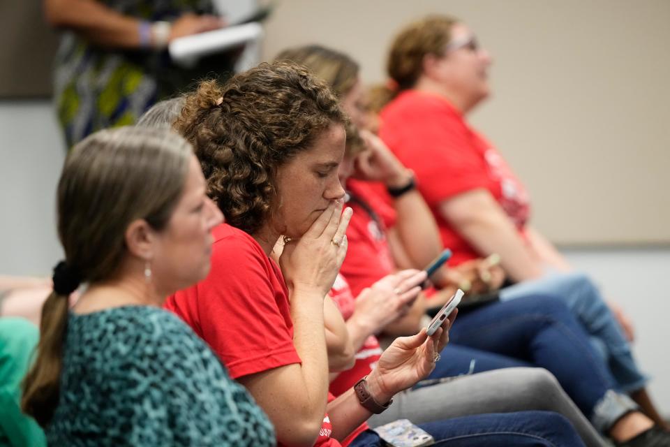 Audience members listen to initial recommendations for the closing of schools during the public comment period Tueday at the Columbus City School Board meeting.