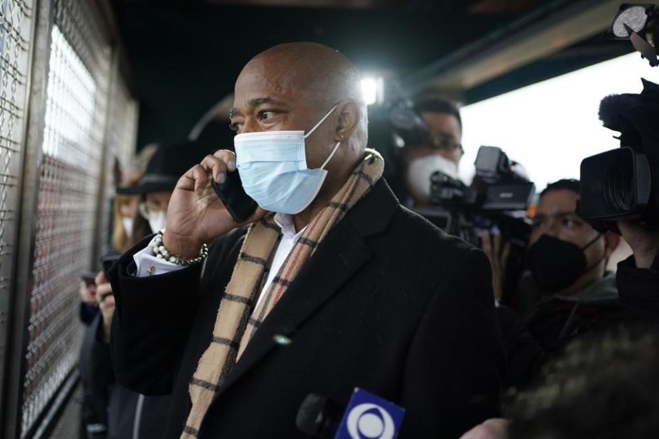New York City Mayor Eric Adams calls the police while keeping his eye on a fight in the street while waiting for the subway to City Hall in New York, Saturday, Jan. 1, 2022. Adams called to report an assault in progress. (AP Photo/Seth Wenig)